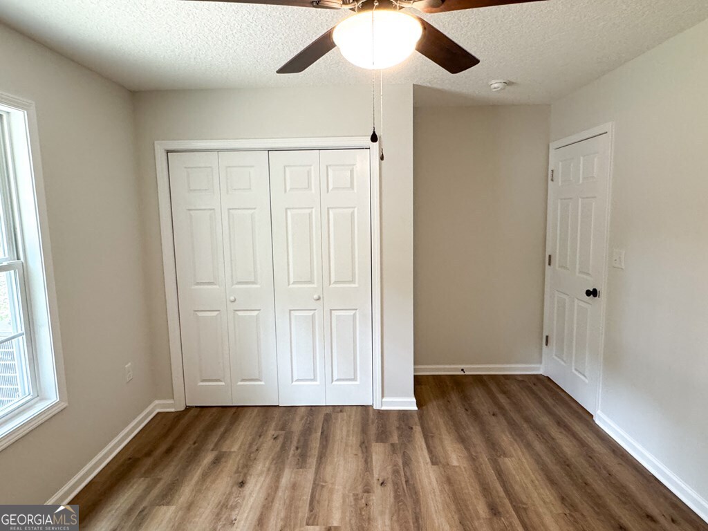 808 Satilla Boulevard Waycross, GA 31501 - Photo 16 of 29 an empty room with wooden floor cabinet and windows