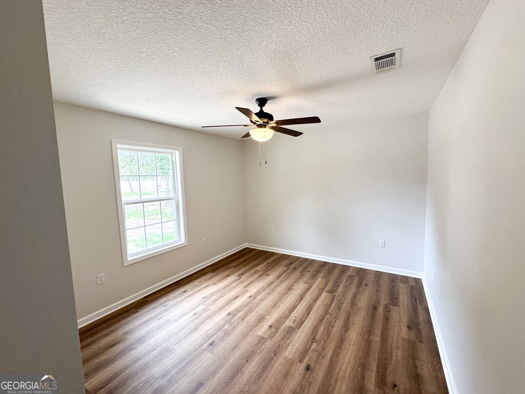 808 Satilla Boulevard Waycross, GA 31501 - Photo 20 of 29 wooden floor in an empty room with a window