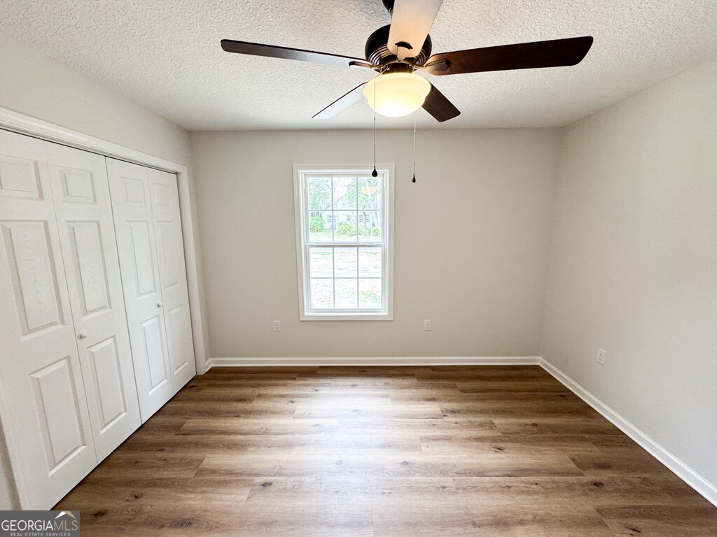 808 Satilla Boulevard Waycross, GA 31501 - Photo 21 of 29 an empty room with wooden floor fan and windows