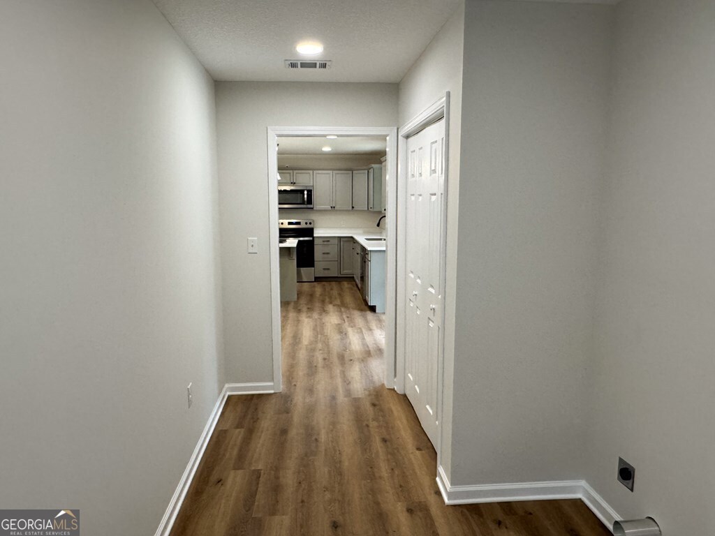 808 Satilla Boulevard Waycross, GA 31501 - Photo 22 of 29 a view of a hallway with wooden floor and a bathroom