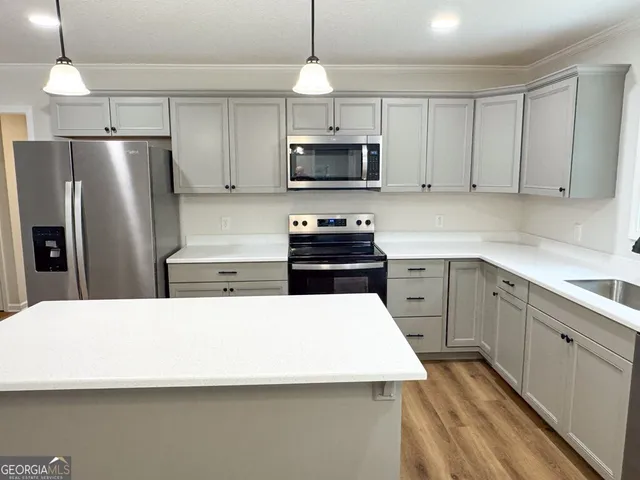 a kitchen with stainless steel appliances a refrigerator stove microwave and sink