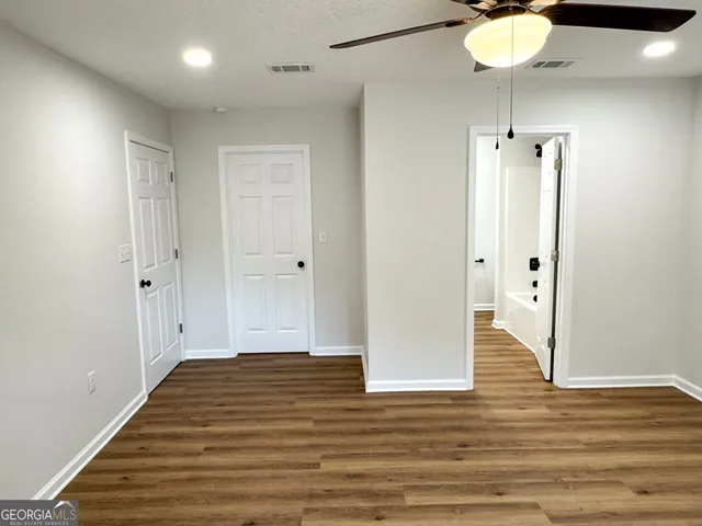 an empty room with wooden floor and mirror