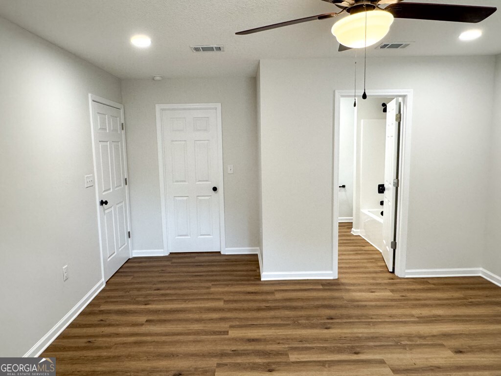 808 Satilla Boulevard Waycross, GA 31501 - Photo 9 of 29 an empty room with wooden floor and mirror