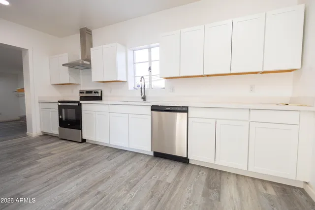 a kitchen with granite countertop white cabinets and white appliances