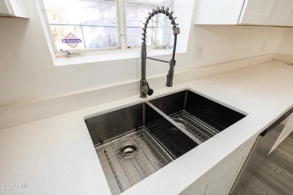 an empty room with wooden floor fan and window