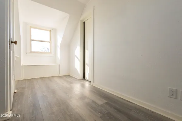 a view of a small space with wooden floor and a window