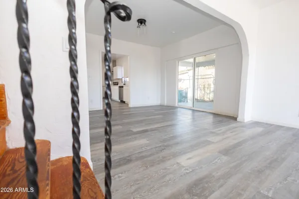a view of empty room with wooden floor and fan