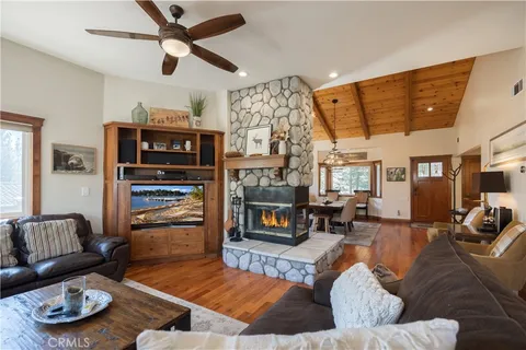a living room with fireplace furniture and a large window
