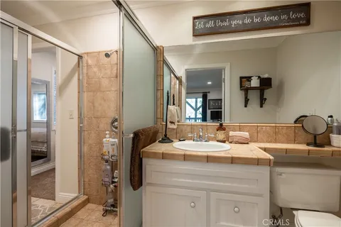 a spacious bedroom with a bed a fireplace and a flat screen tv