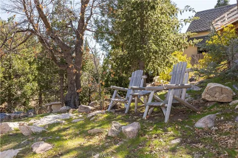 a view of a house with a yard and large trees