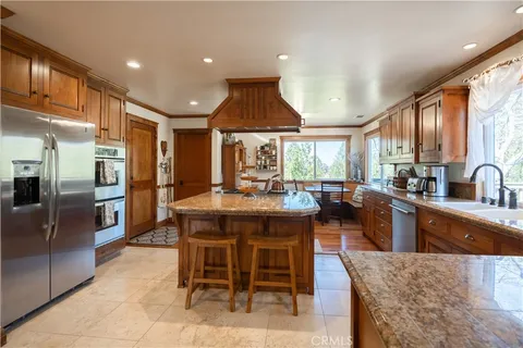 a large kitchen with kitchen island granite countertop a large window and counter space