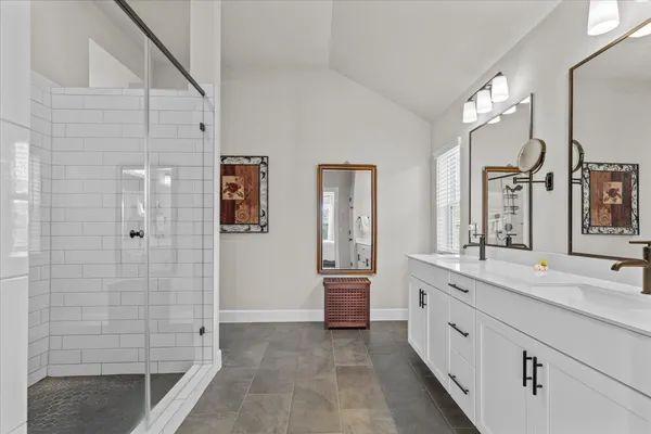 a bathroom with a double vanity sink a mirror and a shower