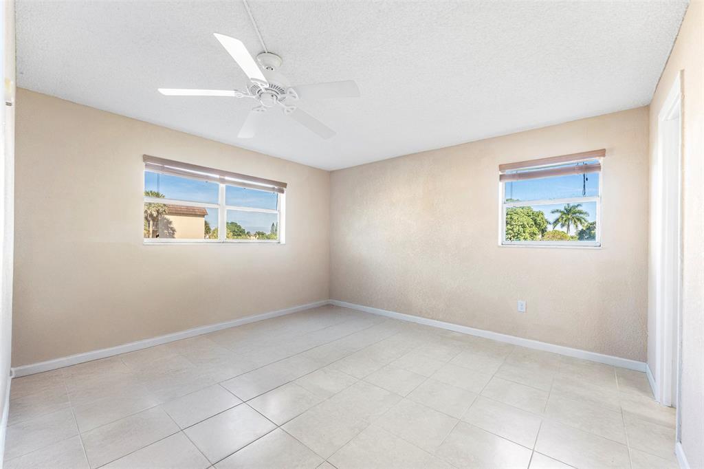 2720 North Pine Island Road, Unit 212 Sunrise, FL 33322 - Photo 15 of 49 an empty room with windows and a ceiling fan
