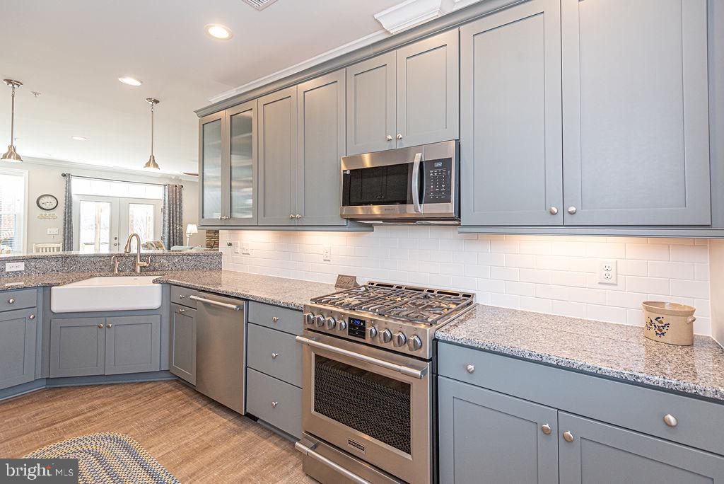 11910 Back Creek Road Bishopville, MD 21813 - Photo 16 of 94 a kitchen with granite countertop white cabinets and stainless steel appliances