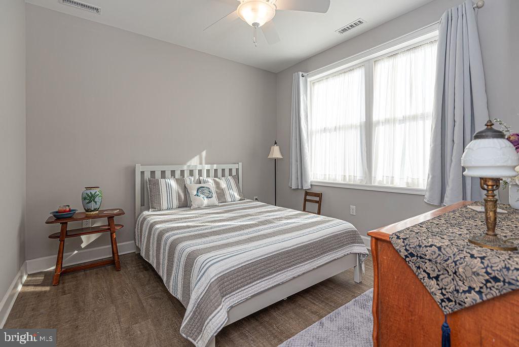 11910 Back Creek Road Bishopville, MD 21813 - Photo 37 of 94 a bedroom with a bed and a chandelier next to a window