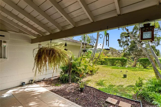 a view of a backyard with plants and patio