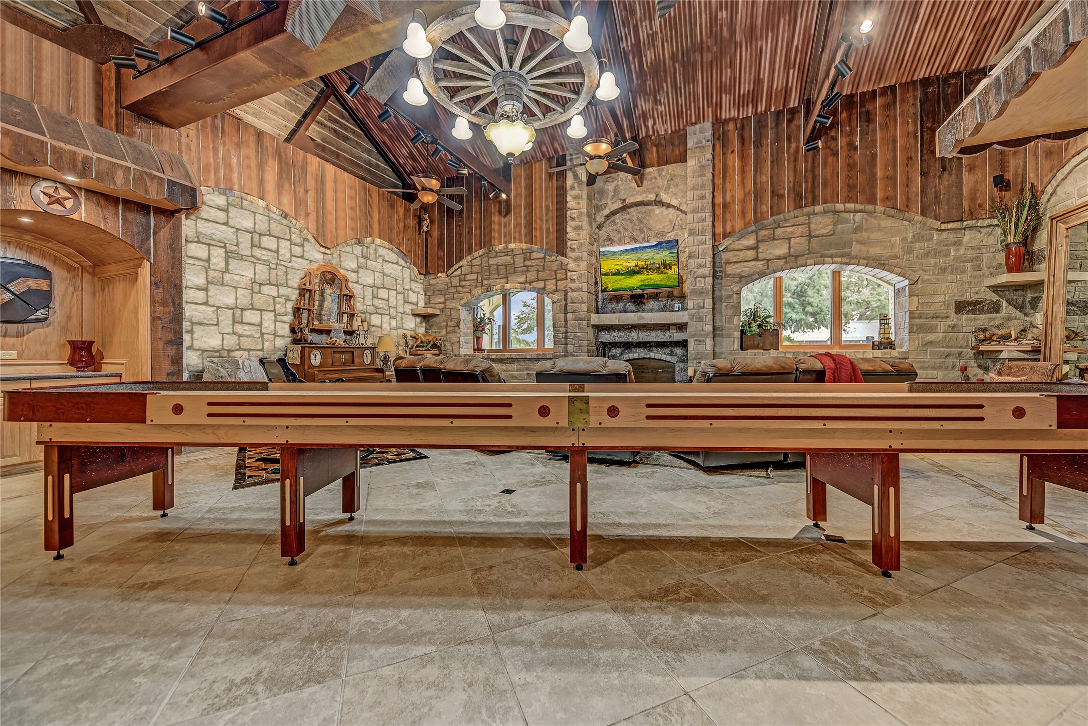 9950 Palestine Road Brenham, TX 77833 - Photo 23 of 49 Designed to entertain, this home has 5 game rooms! The main downstairs game room is anchored between the poker room, pool table room, 1,700+ SF bunkhouse, recreational pool area, and leads to the saloon, outdoor kitchen, and commercial dining room.