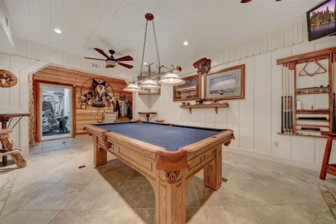 a room with lots of wooden furniture and stainless steel appliances
