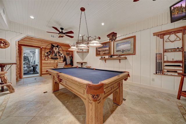 a room with lots of wooden furniture and stainless steel appliances