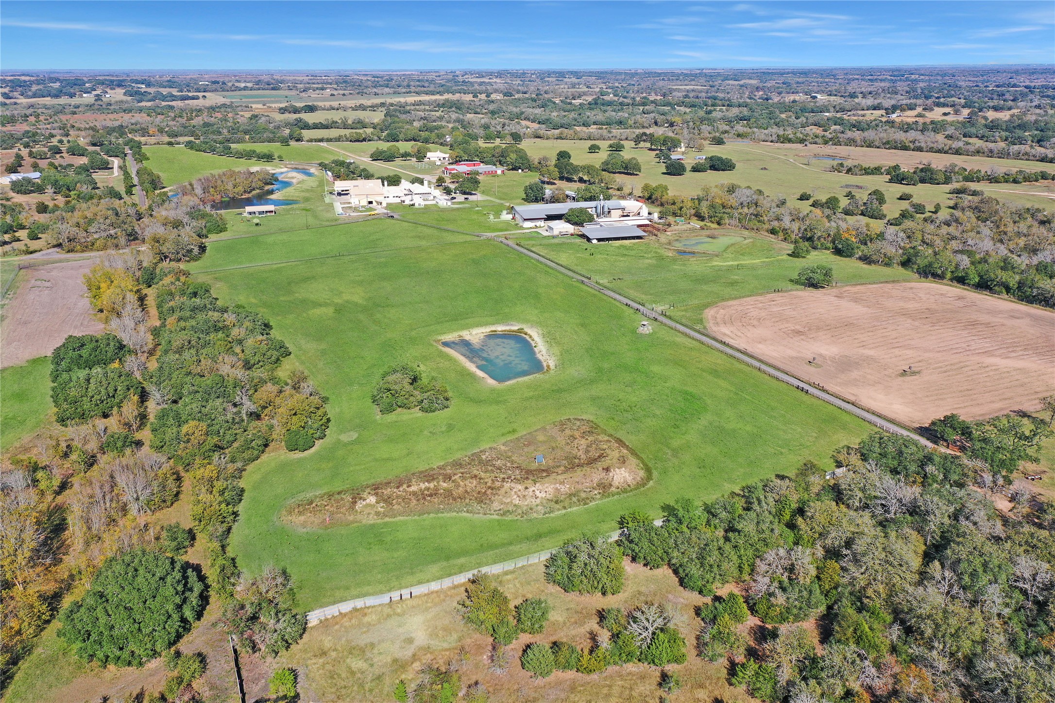 9950 Palestine Road Brenham, TX 77833 - Photo 41 of 49 The middle portion of this masterfully planned property is complete with 2 additional ponds, the target from the indoor shooting range, and an asphalt road separating multiple cross-fenced pastures. The horse barn and cattle working area both lead directly to this portion of the land.