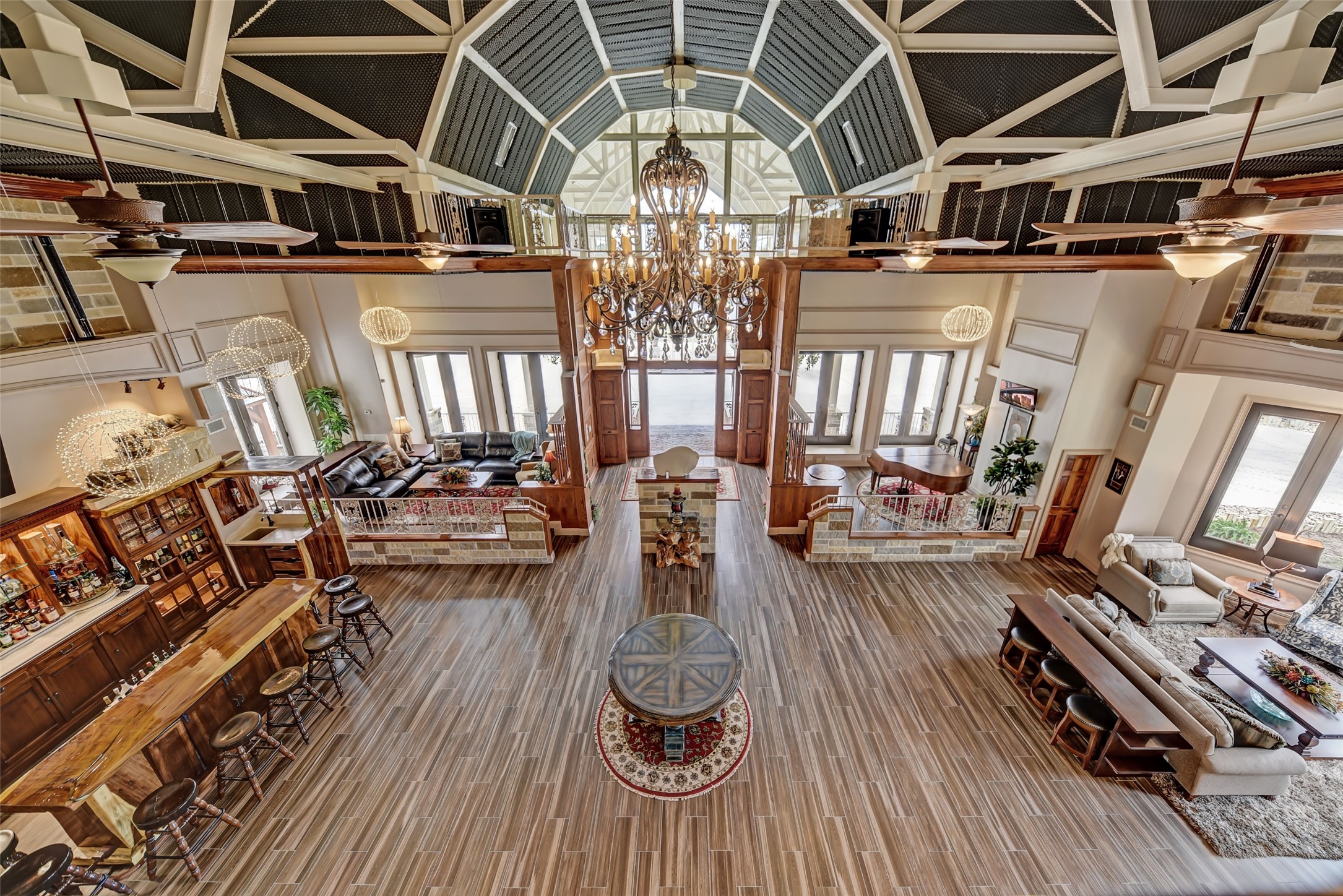 9950 Palestine Road Brenham, TX 77833 - Photo 9 of 49 Notice the extensive architectural details of the soaring 35' ceilings with steel trusses and a monorail extending from one side of the great room to the other. This view from the upstairs game room highlights the two elevated sitting areas anchoring the front door, the custom bar area, and the spacious sitting area overlooking the frontline driveway.
