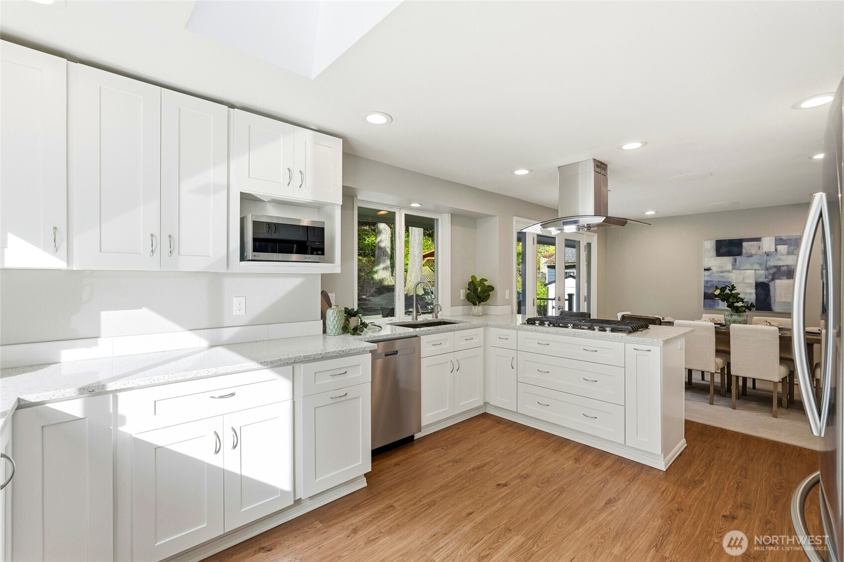 4822 Fowler Avenue Everett, WA 98203 - Photo 10 of 40 a kitchen with a stove a sink and white cabinets with wooden floor