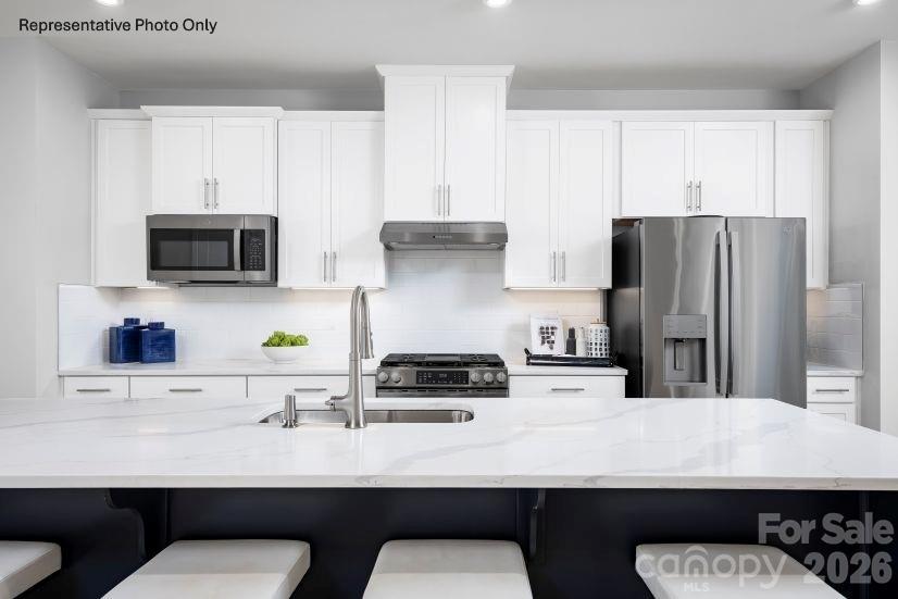 2283 Flicker Road, Unit 1050C Indian Land, SC 29707 - Photo 4 of 17 a kitchen with stainless steel appliances a sink a stove a refrigerator a counter top space and cabinets