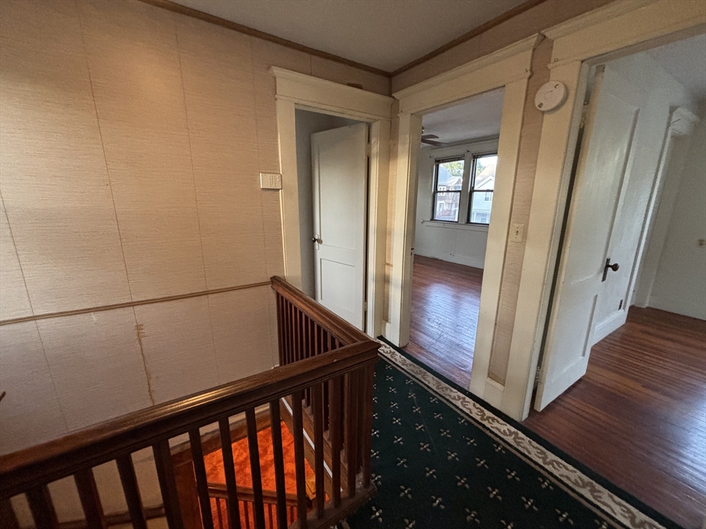 88 Dunmoreland Street Springfield, MA 01109 - Photo 12 of 29 a view of a hallway with wooden floor and staircase