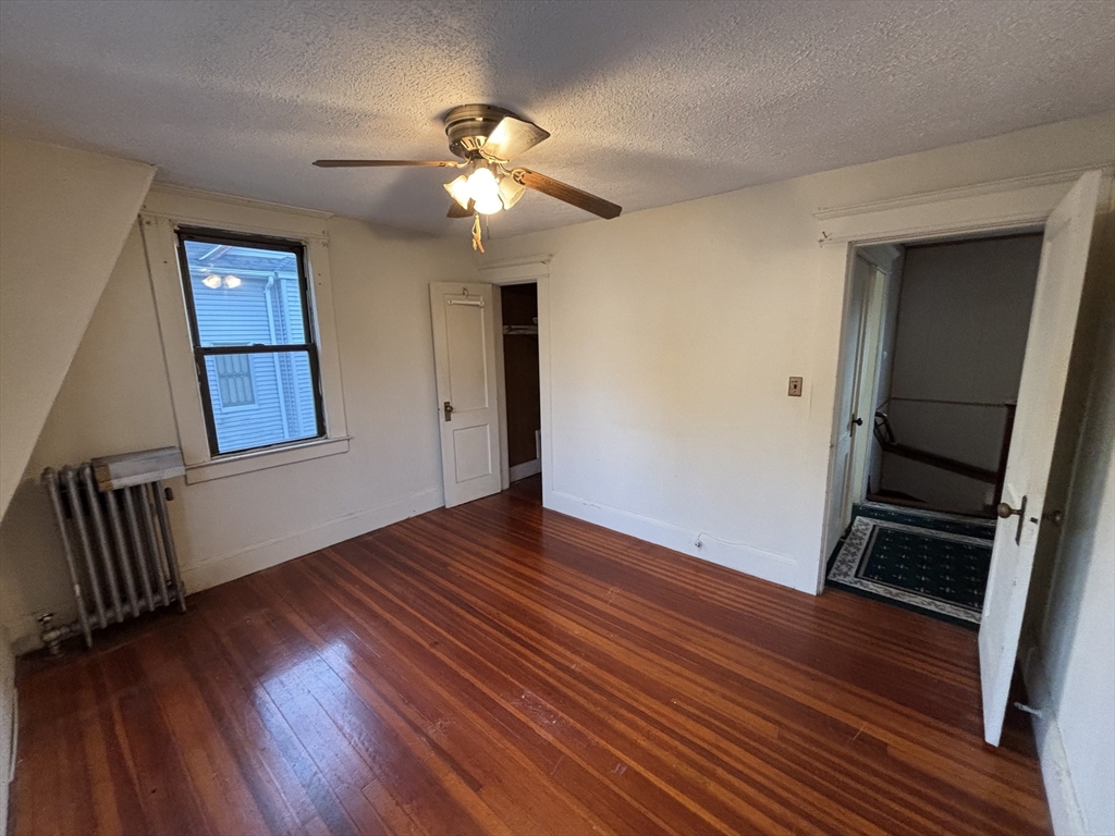 88 Dunmoreland Street Springfield, MA 01109 - Photo 13 of 29 a view of an empty room with wooden floor and a ceiling fan