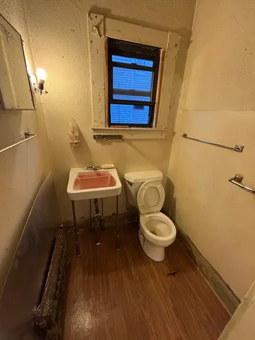 a bathroom with a toilet a sink and a mirror