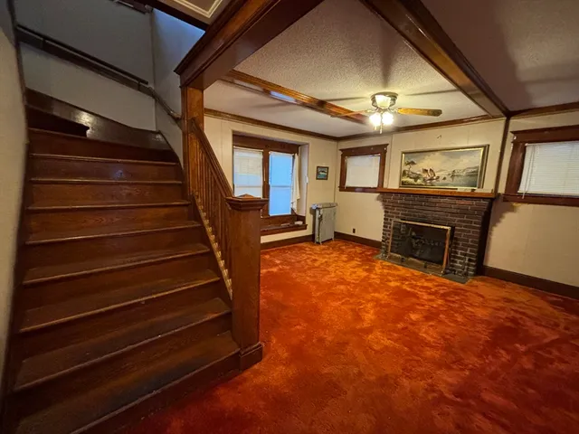 a view of an empty room with stairs and a stove