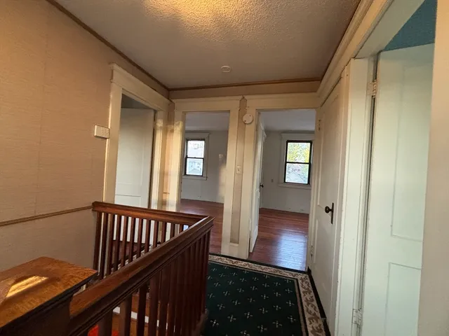 a view of a hallway with wooden floor and stairs