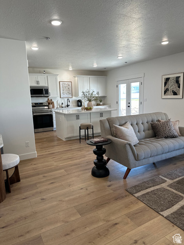 7927 Bristlecone Road, Unit 204 Eagle Mountain, UT 84005 - Photo 15 of 19 Living area featuring recessed lighting, light wood-style flooring, a textured ceiling, and french doors