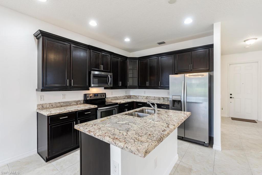 5423 Useppa Drive Ave Maria, FL 34142 - Photo 3 of 35 a kitchen with stainless steel appliances granite countertop a sink stove and refrigerator