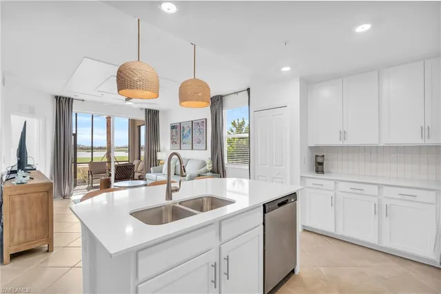 a kitchen with stainless steel appliances granite countertop a sink a stove and a wooden floor