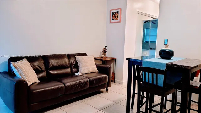 a living room with furniture and a painting on the wall