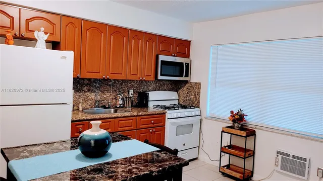 a kitchen with stainless steel appliances a stove a sink and a refrigerator