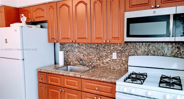 a kitchen with granite countertop cabinets and black appliances
