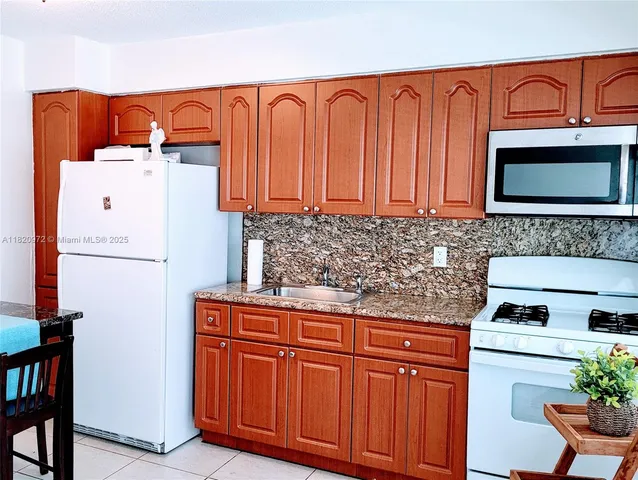 a kitchen with stainless steel appliances granite countertop a refrigerator and a stove top oven