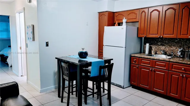 a kitchen with stainless steel appliances granite countertop a table and a refrigerator