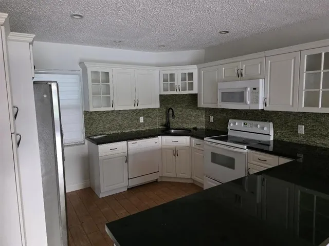 a view of a lake with a yard and large trees