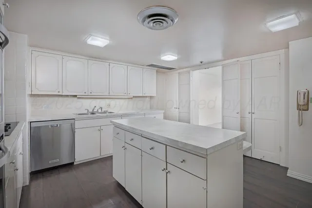 a kitchen with cabinets appliances a sink and a counter top space