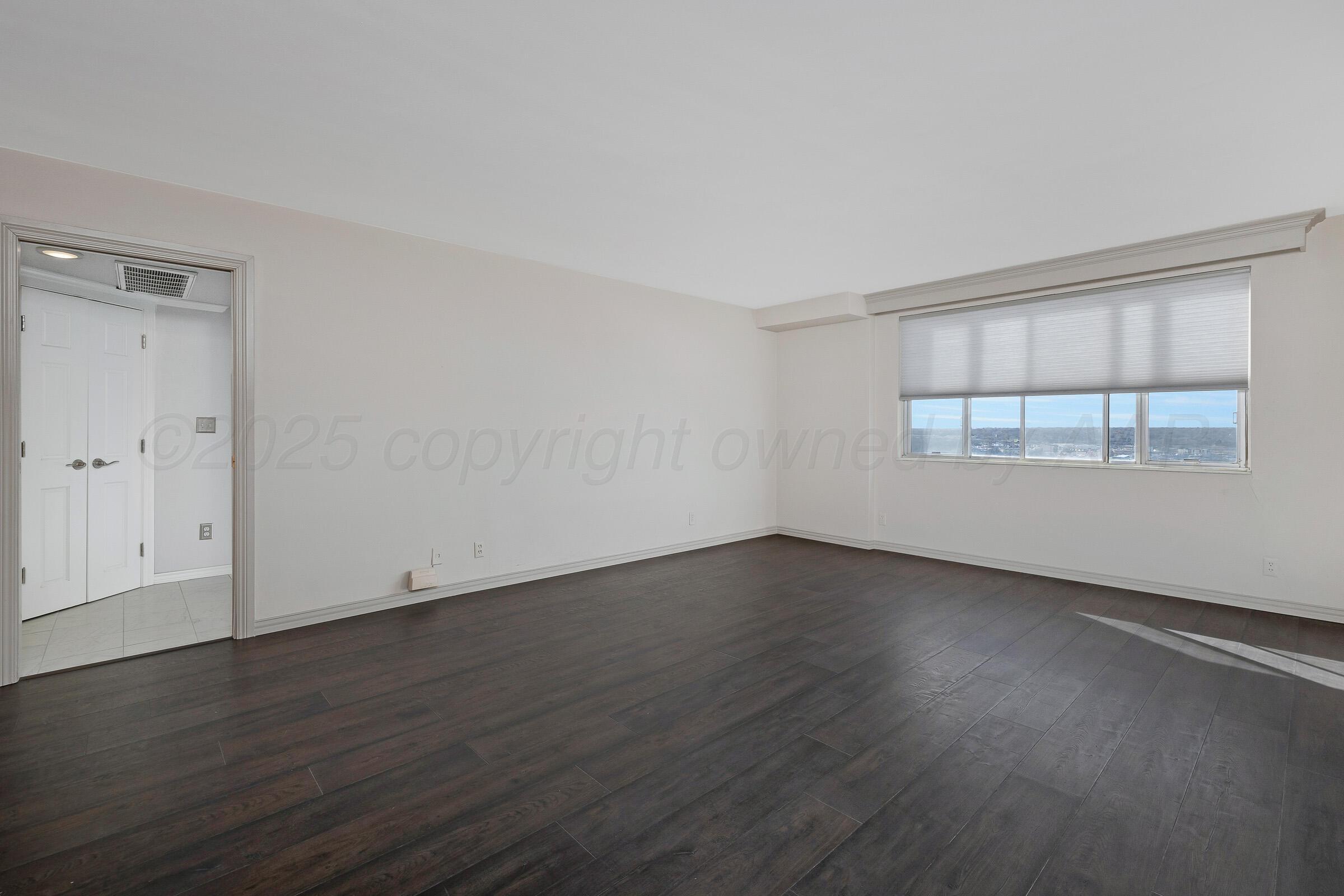 2028 South Austin Street, Unit 1104 Amarillo, TX 79109 - Photo 15 of 37 an empty room with wooden floor and windows