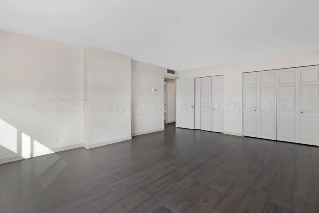 a view of an empty room with wooden floor