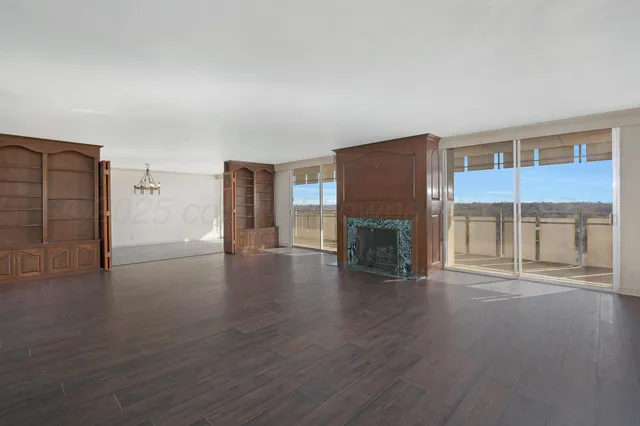 a view of empty room with wooden floor and fireplace