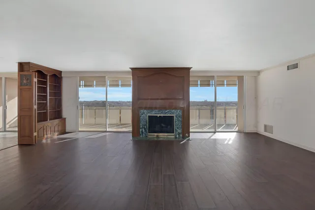 an empty room with wooden floor and fireplace