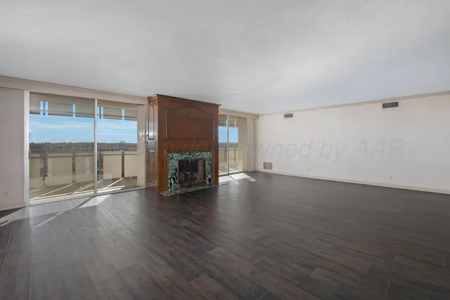 a view of empty room with wooden floor and fireplace