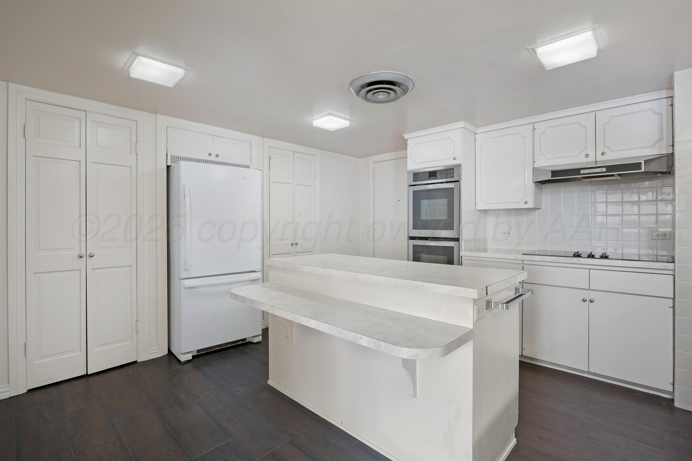 2028 South Austin Street, Unit 1104 Amarillo, TX 79109 - Photo 10 of 37 a white kitchen with stainless steel appliances granite countertop a refrigerator and a stove top oven