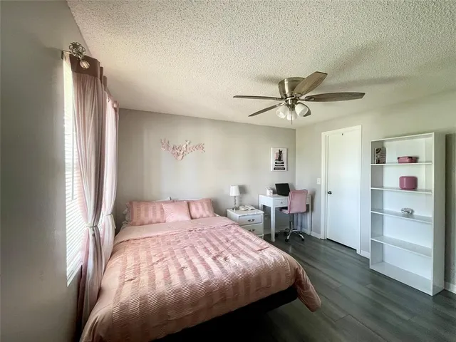 a spacious bedroom with a bed and a flat screen tv