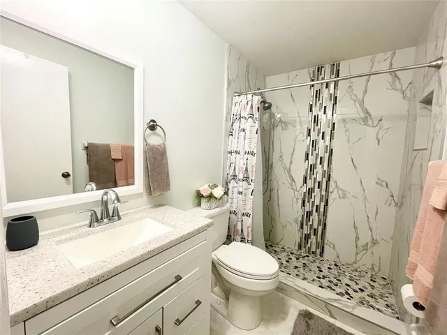 a bathroom with a sink toilet and shower